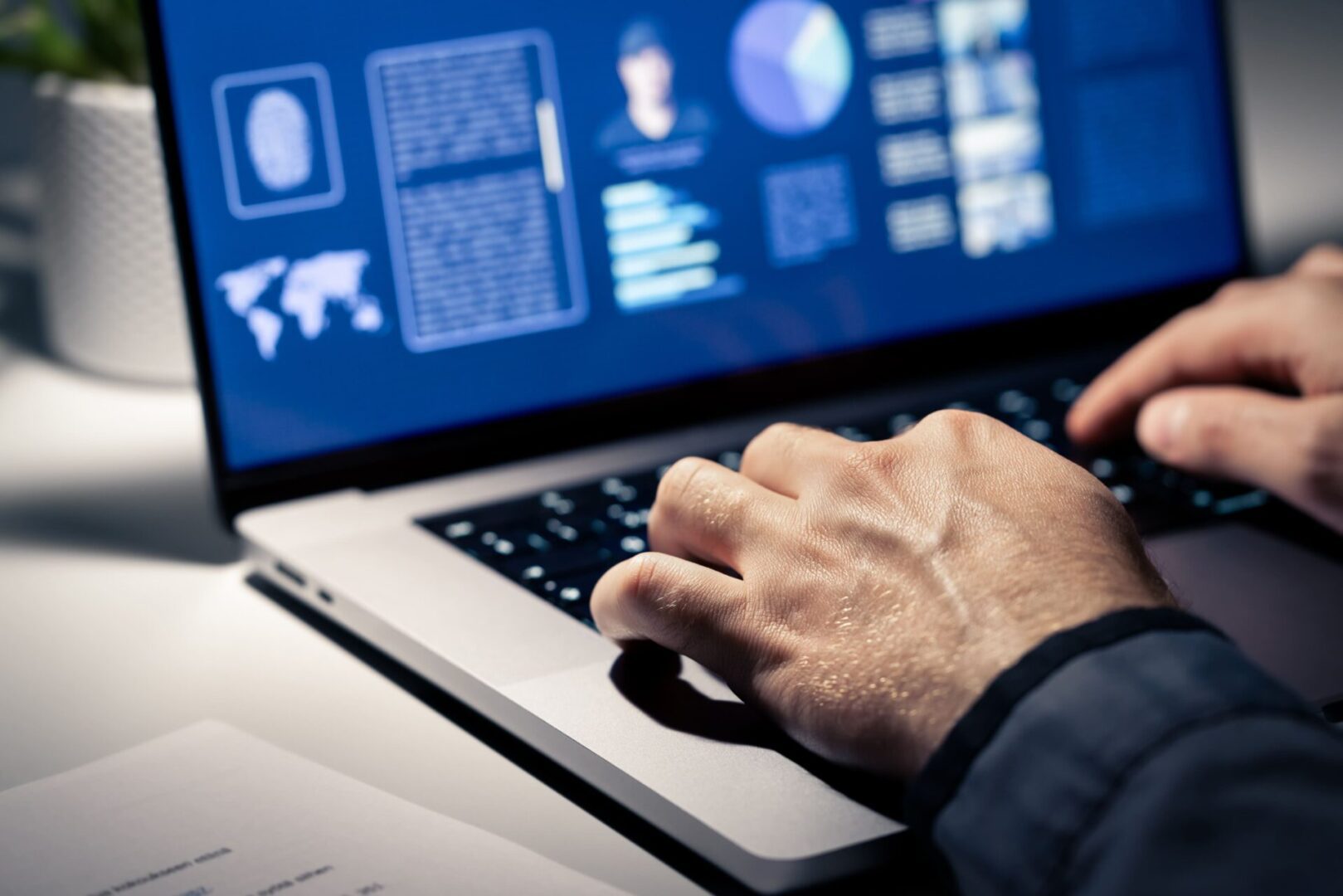 A person using a laptop on top of a desk.